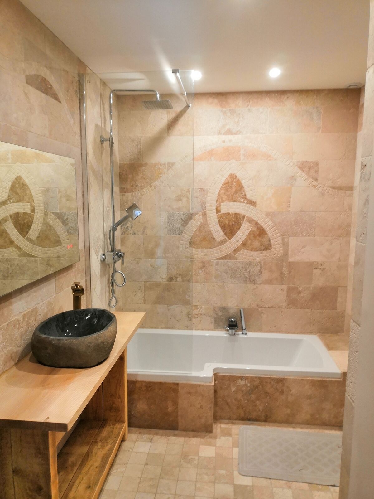 Maison fin 19e entièrement restaurée - Salle de bain toute en travertin avec son discret Triskel qui se reflète dans le miroir connecté